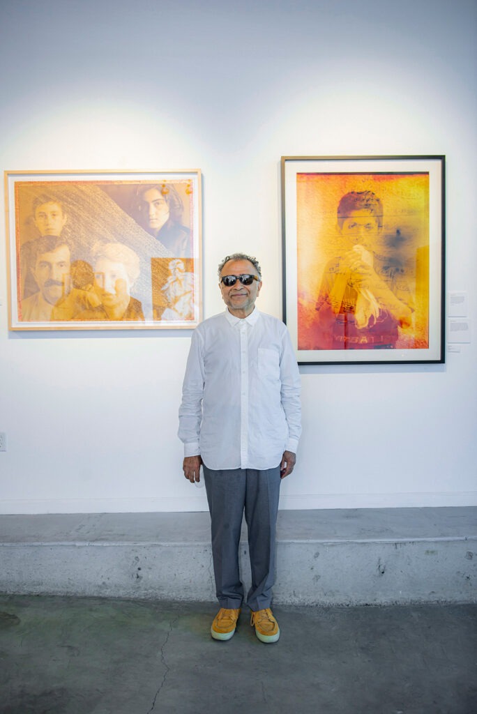 Full body portrait of Hadi Salehi in front of two original printed photographs